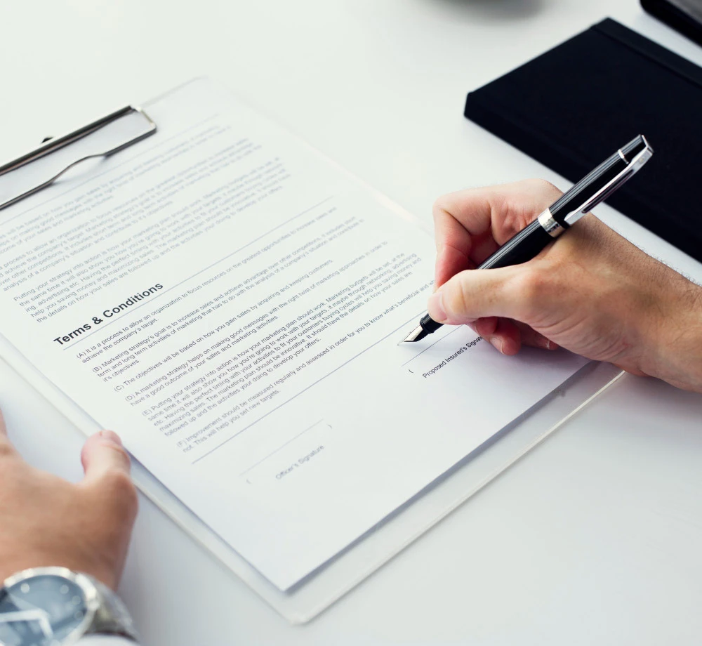 Person signing official educational documents with a fountain pen