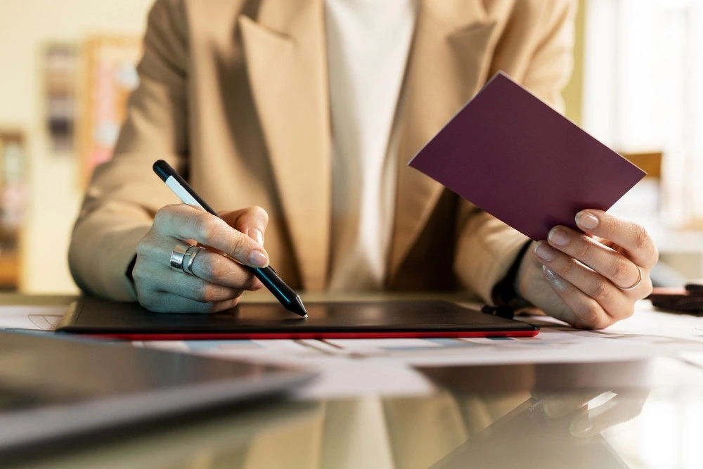 Woman signing papers while holding passport