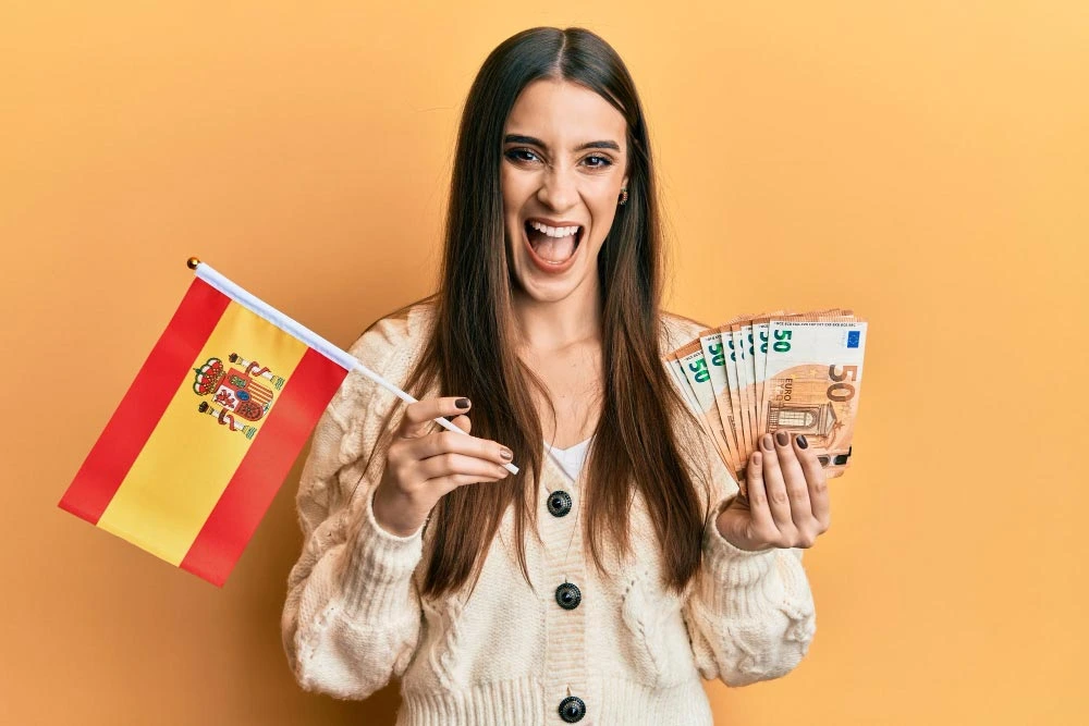 Happy woman holding euros Spanish flag